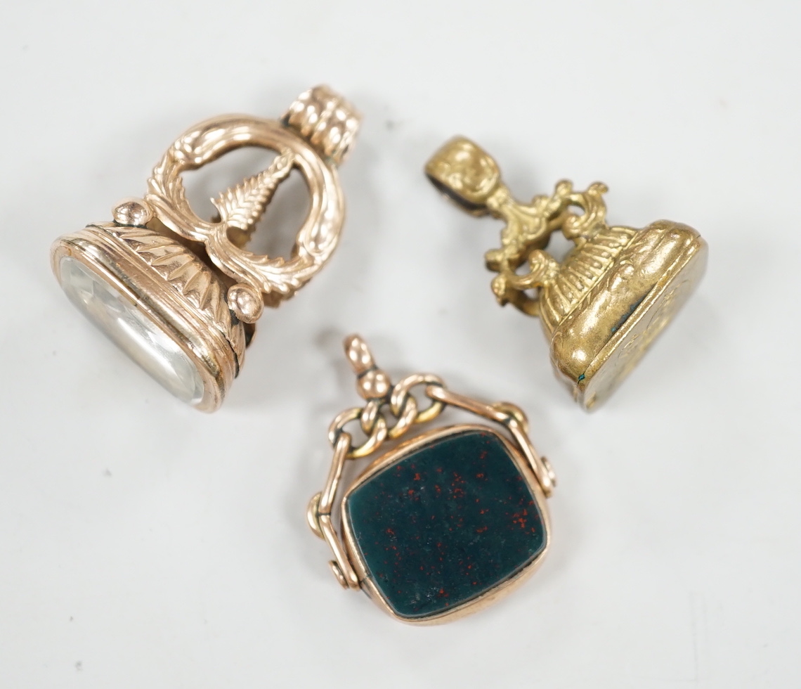 An Edwardian 9ct gold and bloodstone set spinning fob seal, 29mm and two other fob seals including yellow metal overlaid.